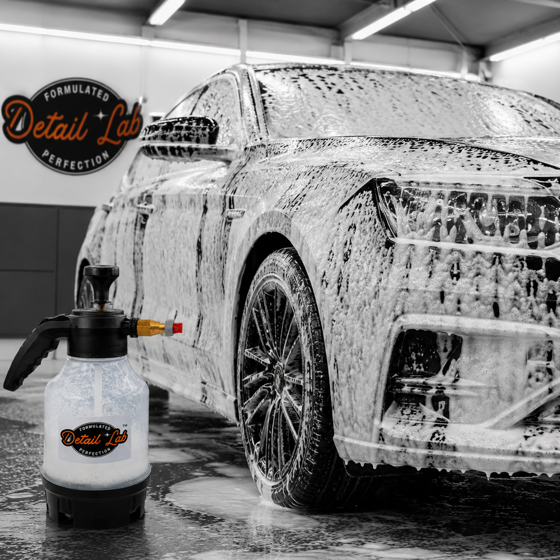 Car being washed with a soapy surface and a bottle of car wash soap in a garage.